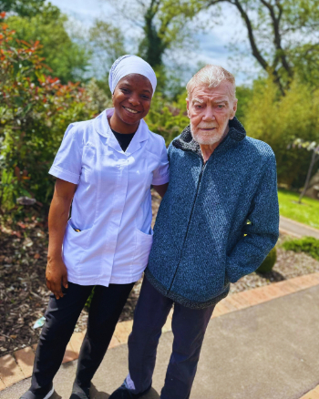 Resident and carer having a walk outside 