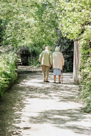 elderly couple walking in the garden 