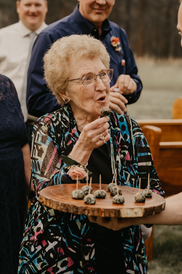 older lady eating canapes